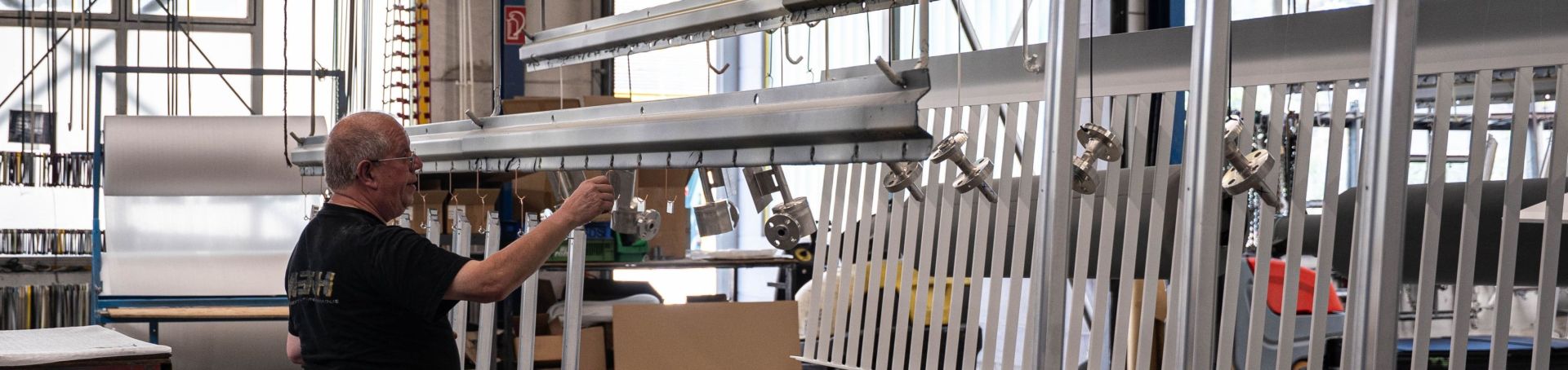 kleine Werkstücke werden vom Werker an die Traverse gehängt