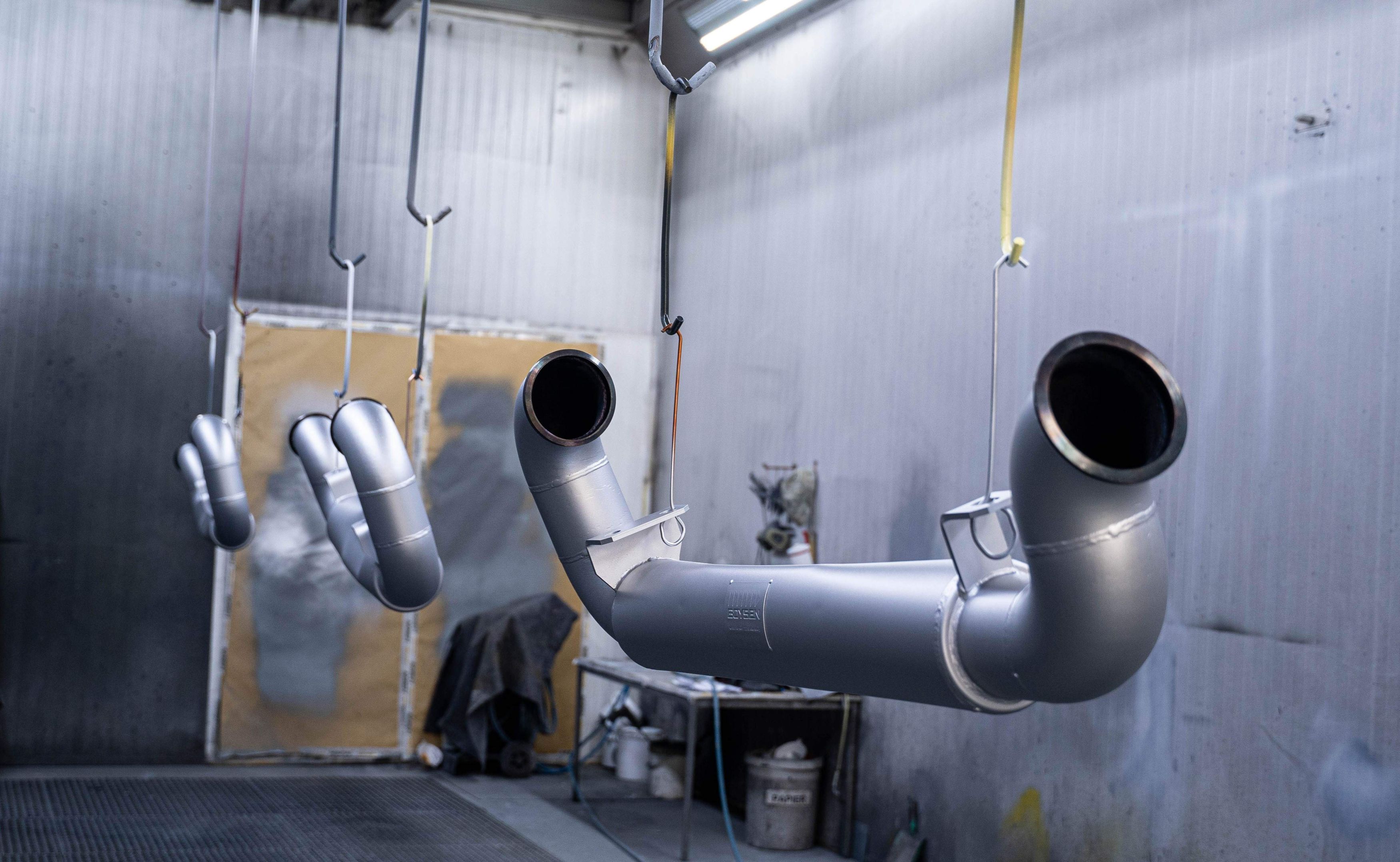 silber lackierte Werkstücke in der Lackierkabine