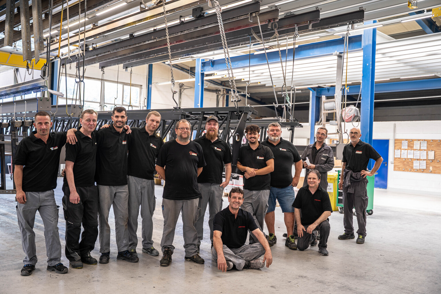 Gruppenbild der Jumbo-Coat Mitarbeiter vor dem Parkplatz